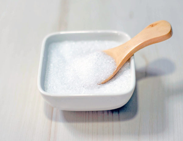 Epsom salts in a square bowl with a wood spoon