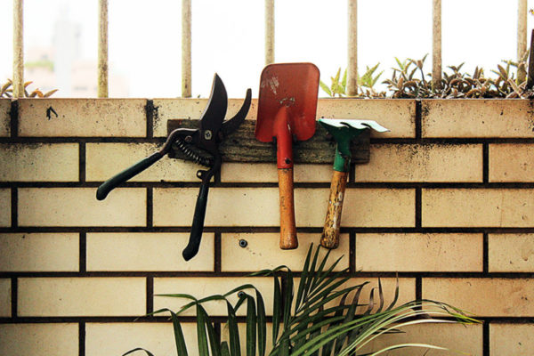 Garden hand tools against a brick wall
